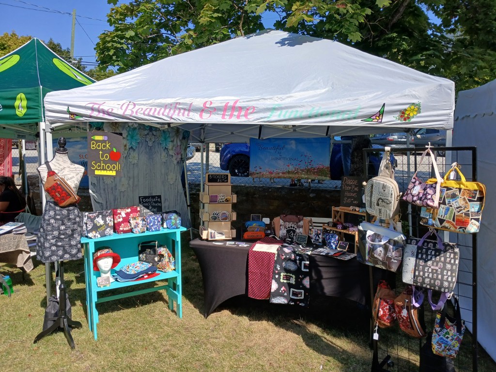 Market tent set up at New Denver.  Bags on display.